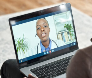 Male black patient on conference video call with female african doctor.