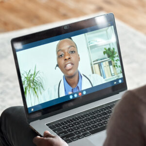 Male black patient on conference video call with female african doctor.