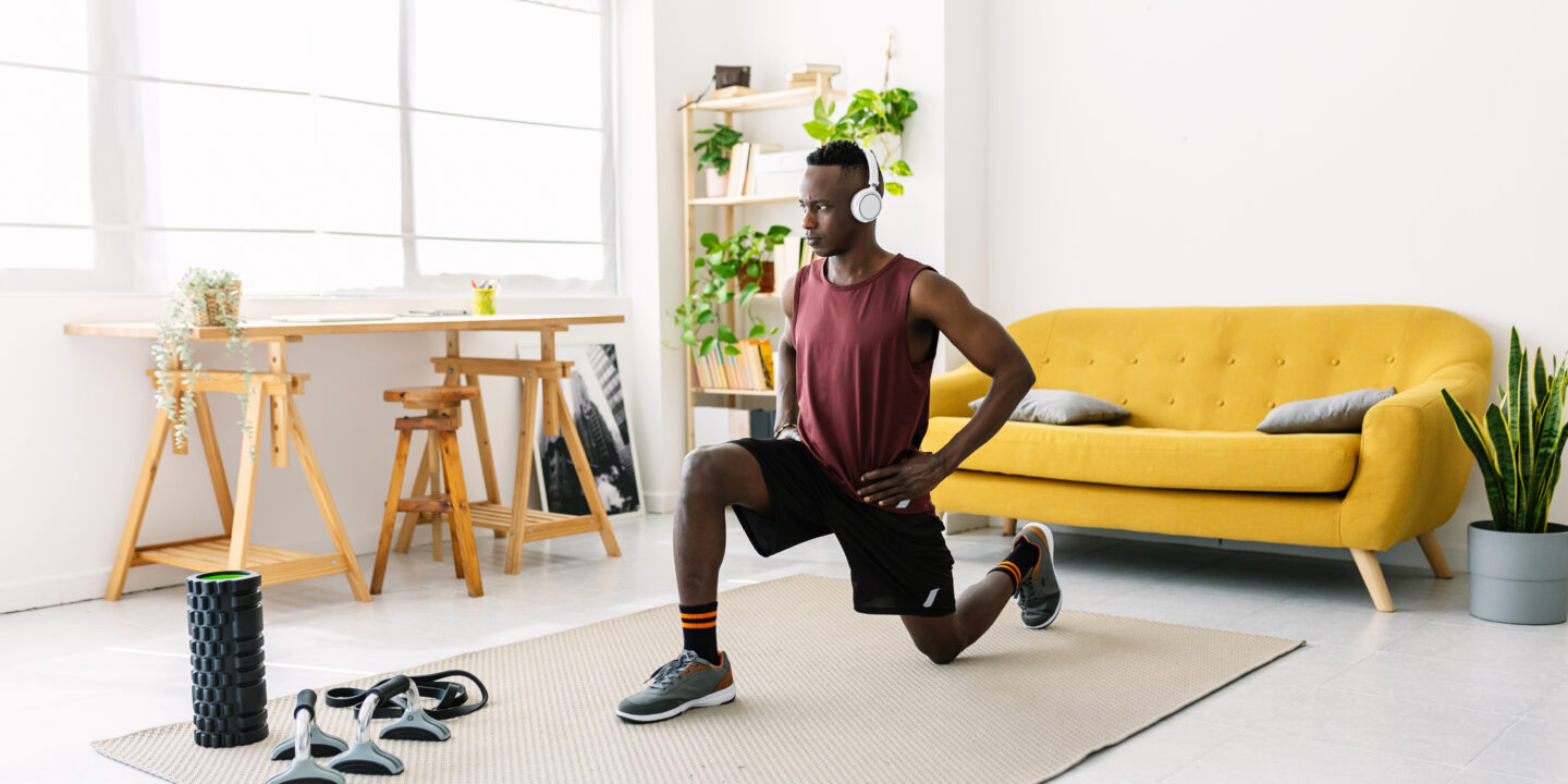 Young african man exercising doing fitness workout at home