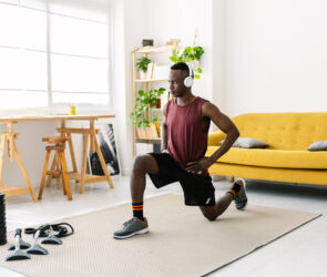 Young african man exercising doing fitness workout at home